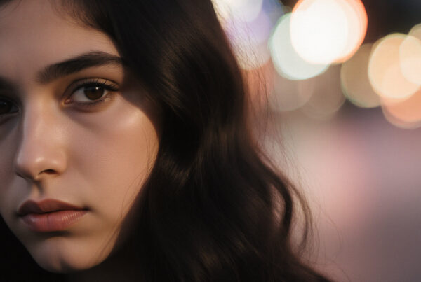 Young woman portrait with bokeh lights, nighttime outdoor scene, artistic photography, emotive gaze, cinematic effect