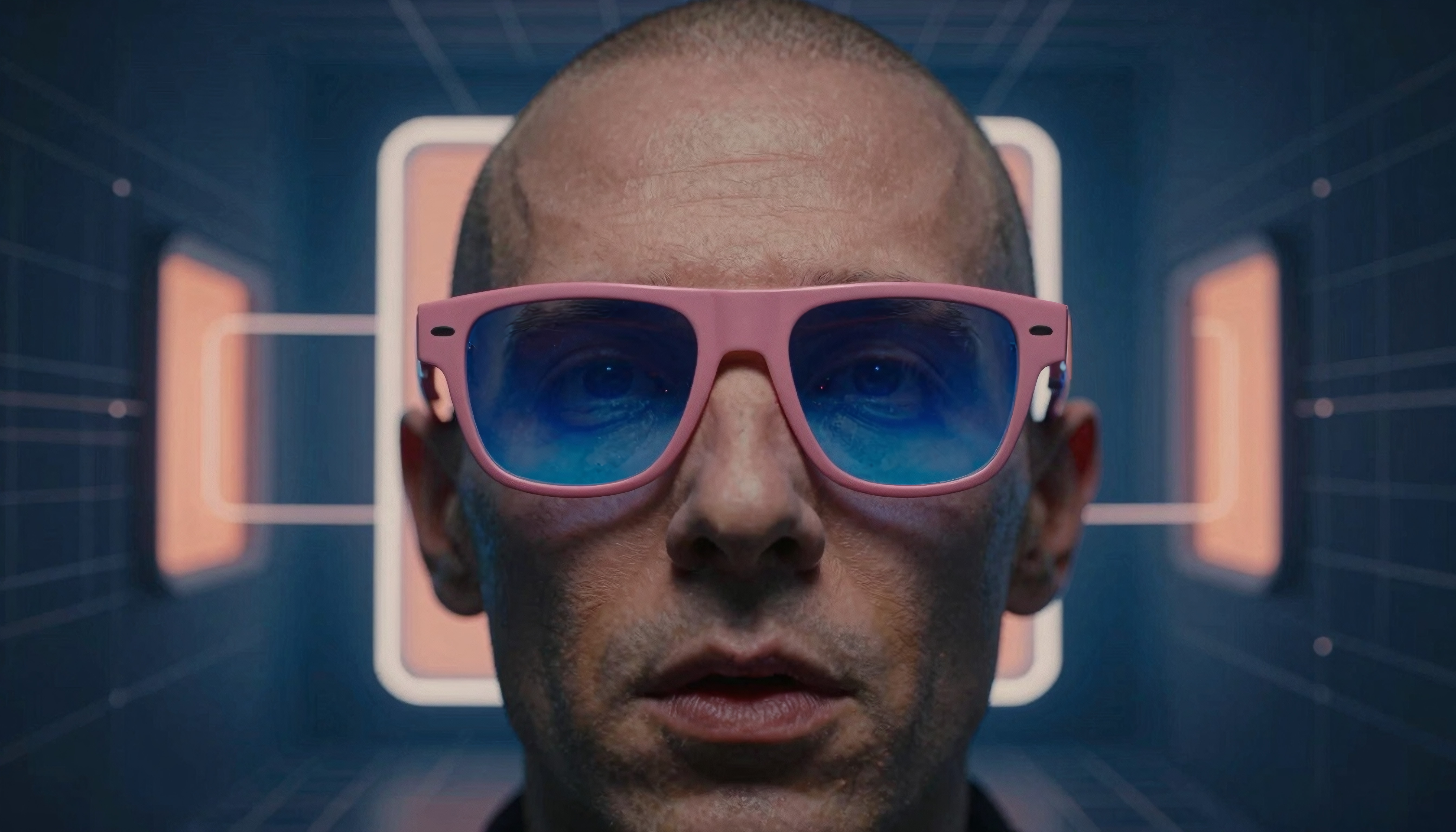 A man wearing pink glasses in a futuristic grid-patterned setting.