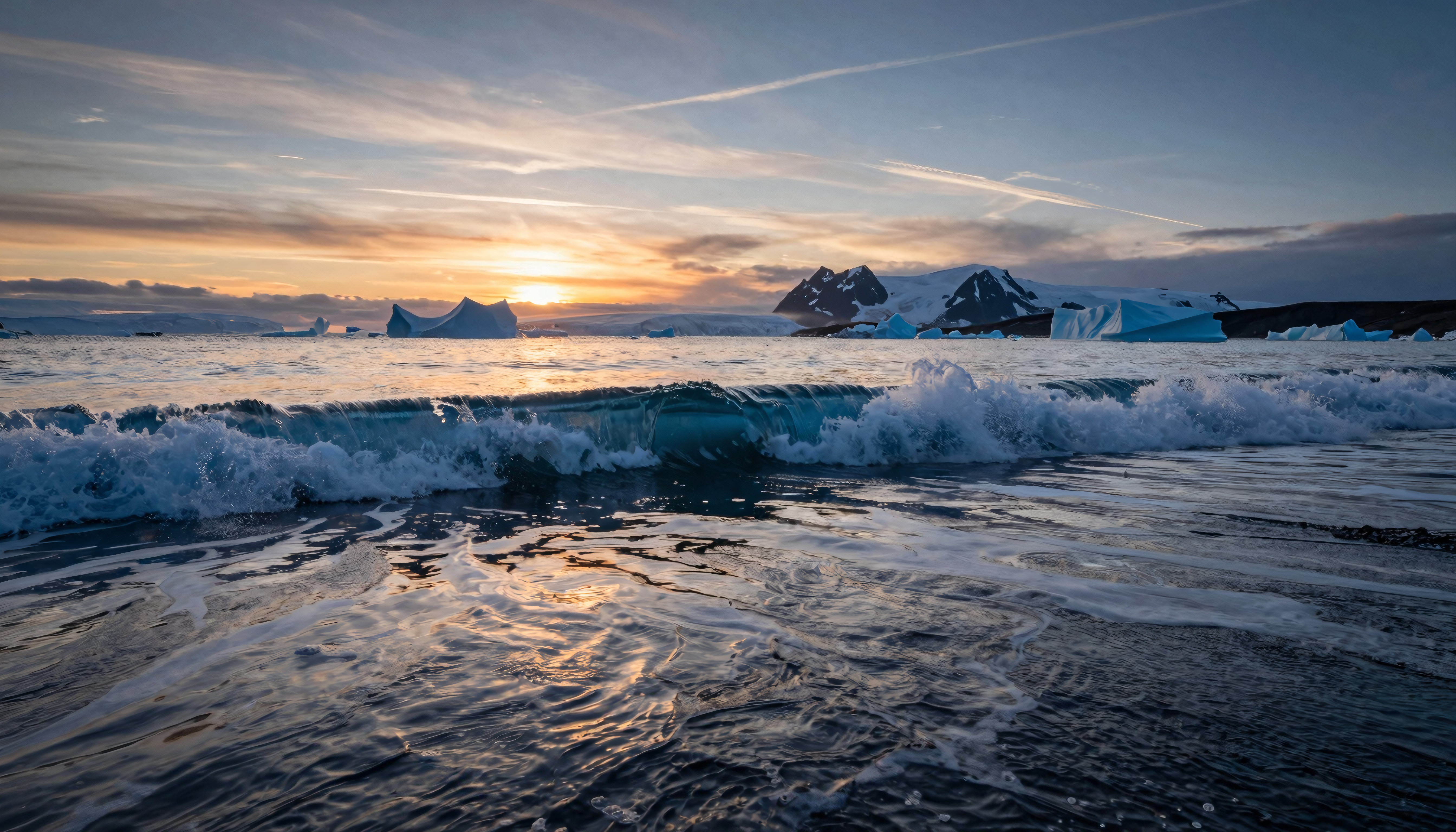 Antarctic Sunset with Icebergs and Ocean Waves