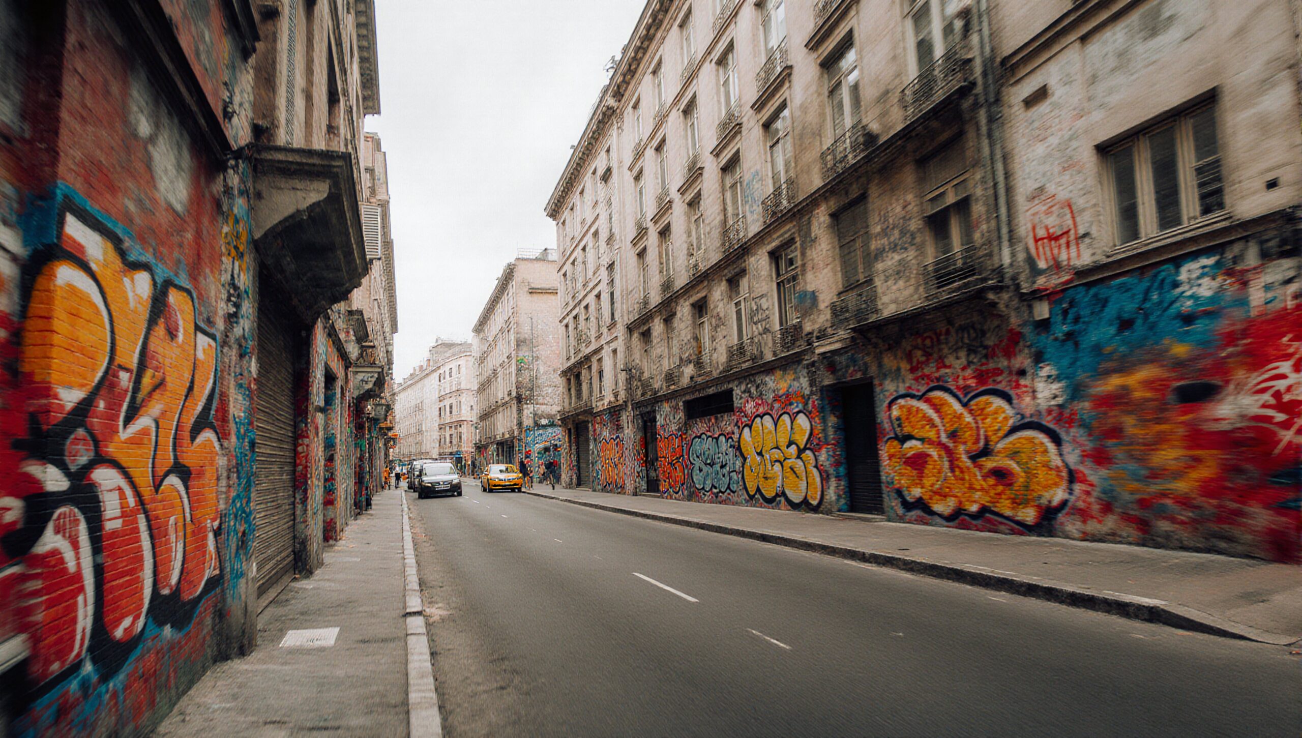 Urban street with vibrant graffiti-covered buildings.