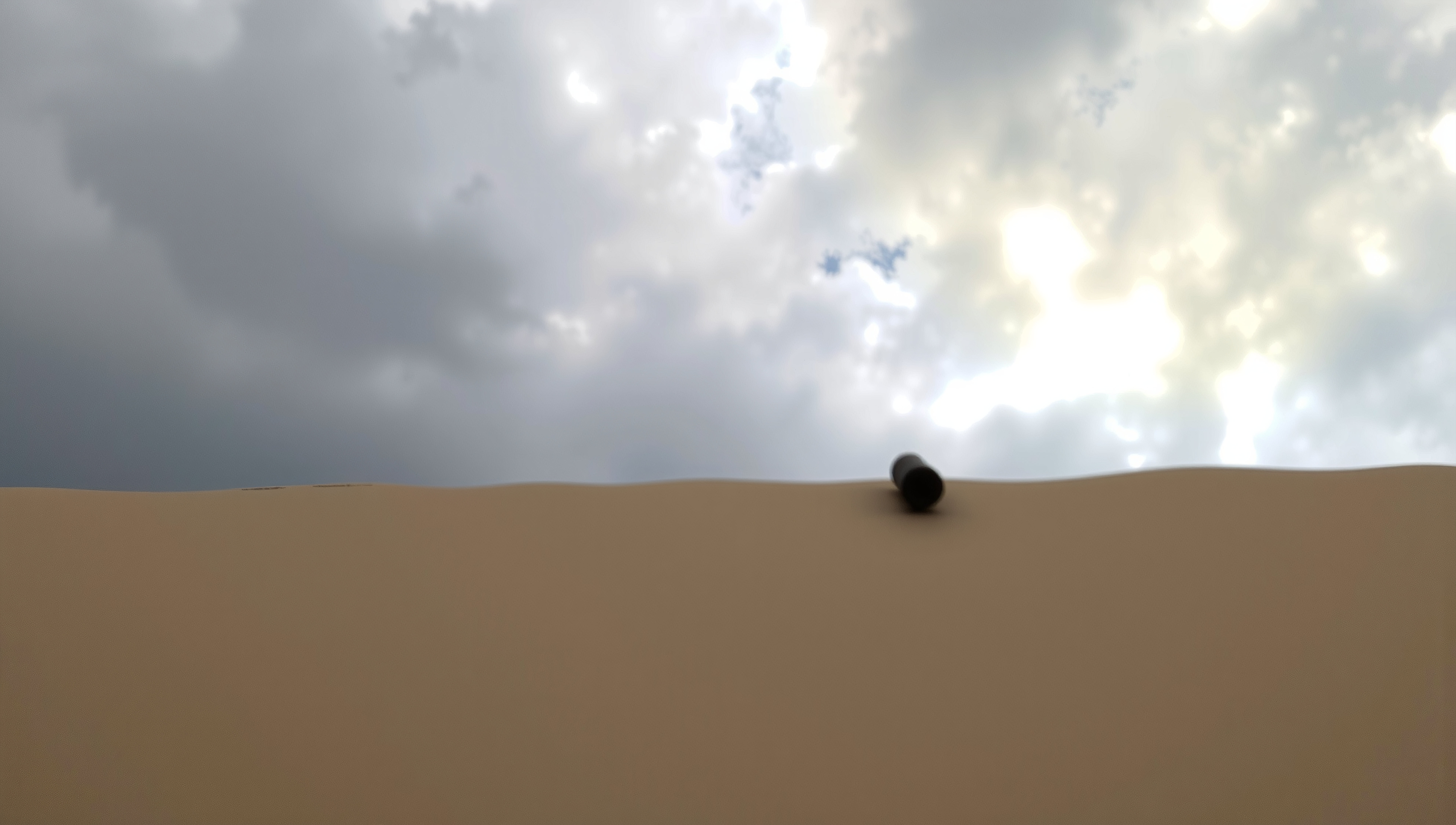 A lone cylinder on a sand dune beneath a dramatic cloudy sky.